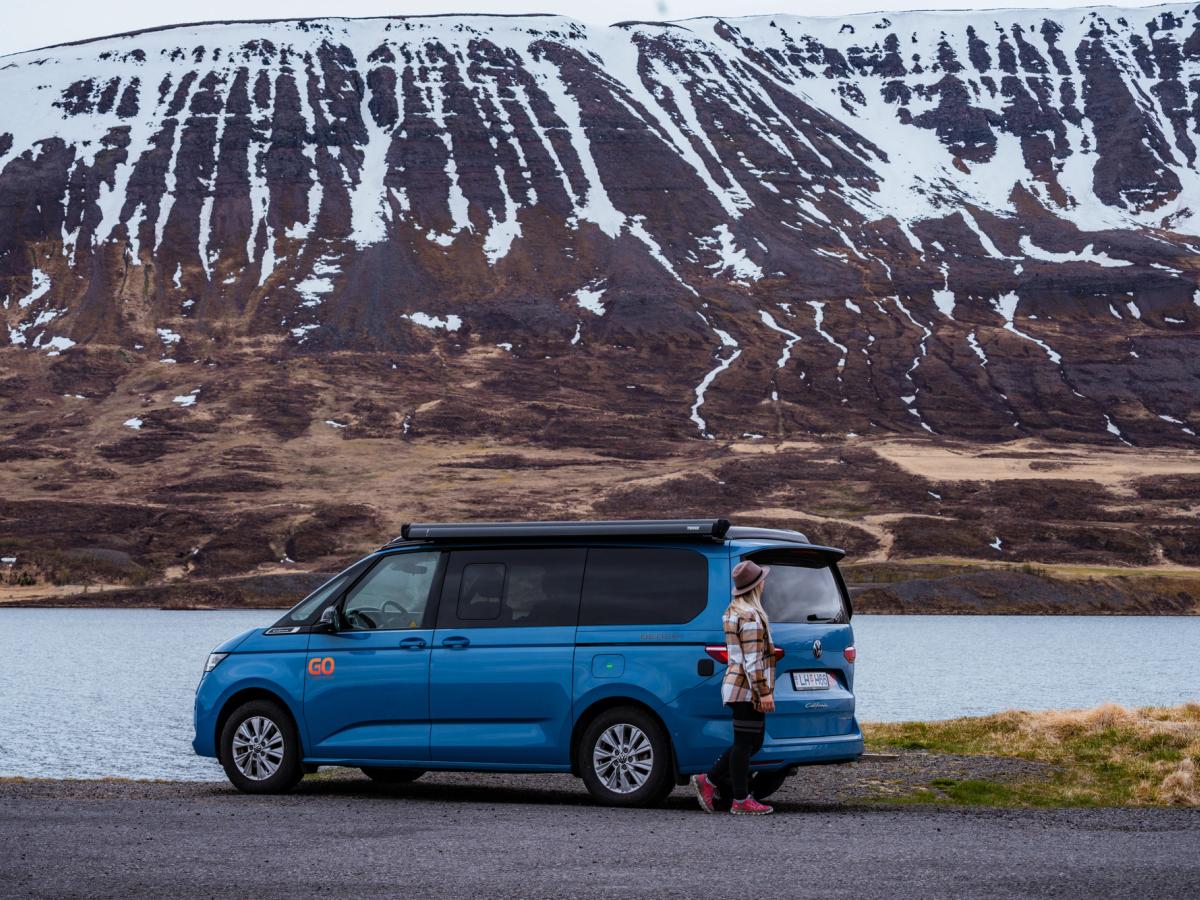 Vue latérale d’un camping-car 4x4 Vue de profil d’un van aménagé 4x4 pour 2 personnes au bord de l’eau, location de van aménagé en Islande
