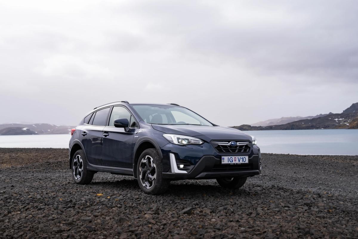 湖畔的斯巴鲁 XV 前视图 冰岛租赁的斯巴鲁 XV SUV 停在湖边的碎石地上,远处群山环绕