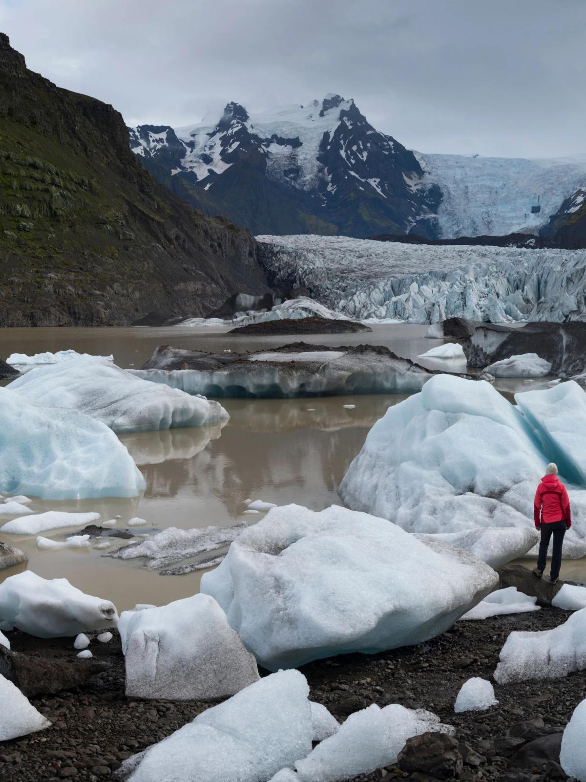 Mujer de espaldas, entre trozos grandes de hielo provinientes del Glaciar Skaftafellsjökull, en el Parque Nacional de Vatnajökull
