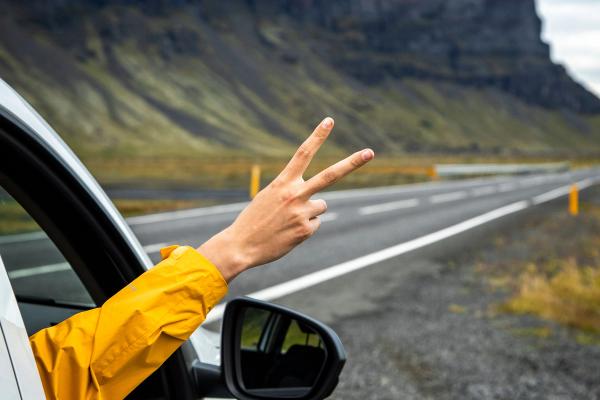 Hand protruding from window Hand making a peace sign from a car window