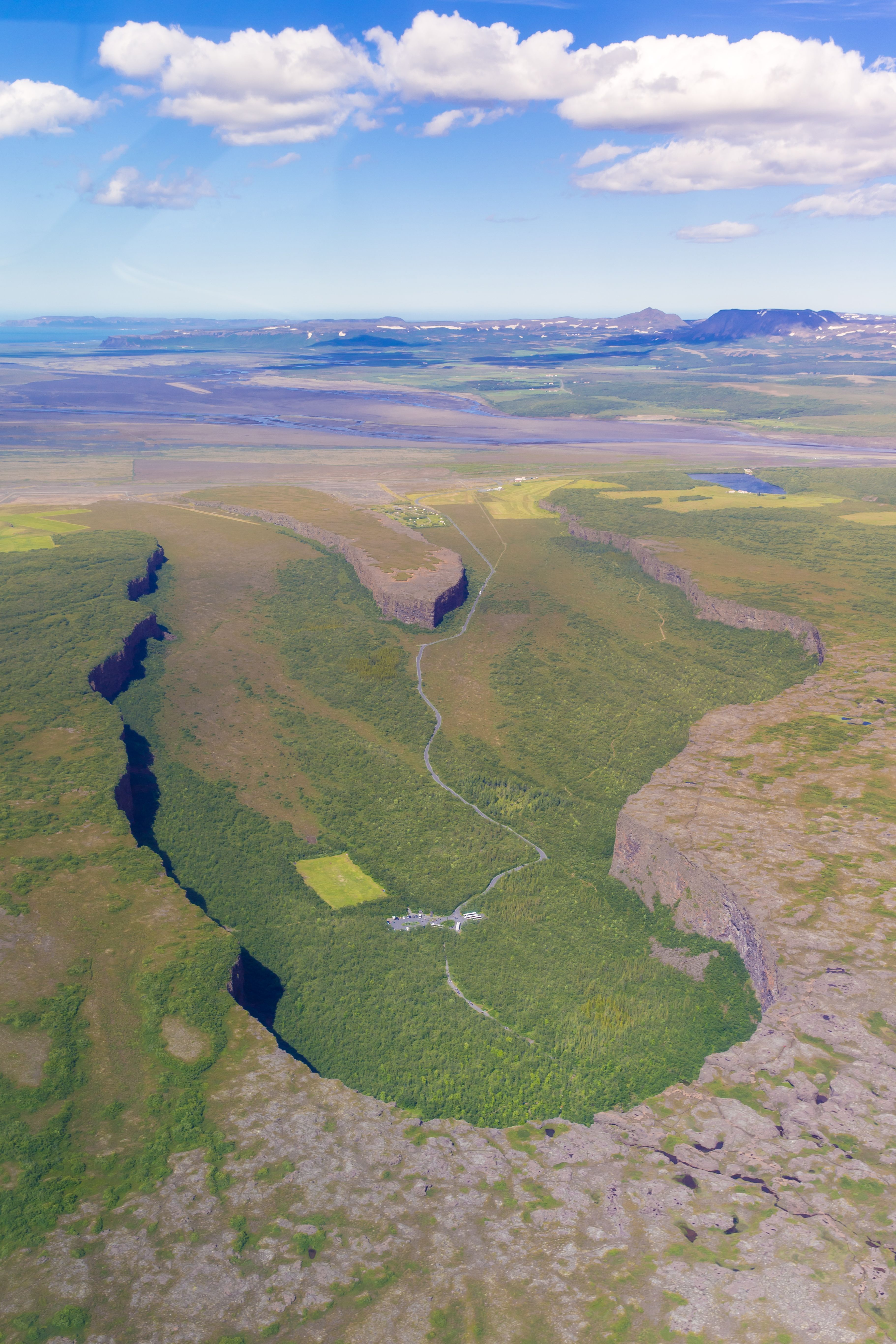 an aerial view of a valley surrounded by mountains and trees