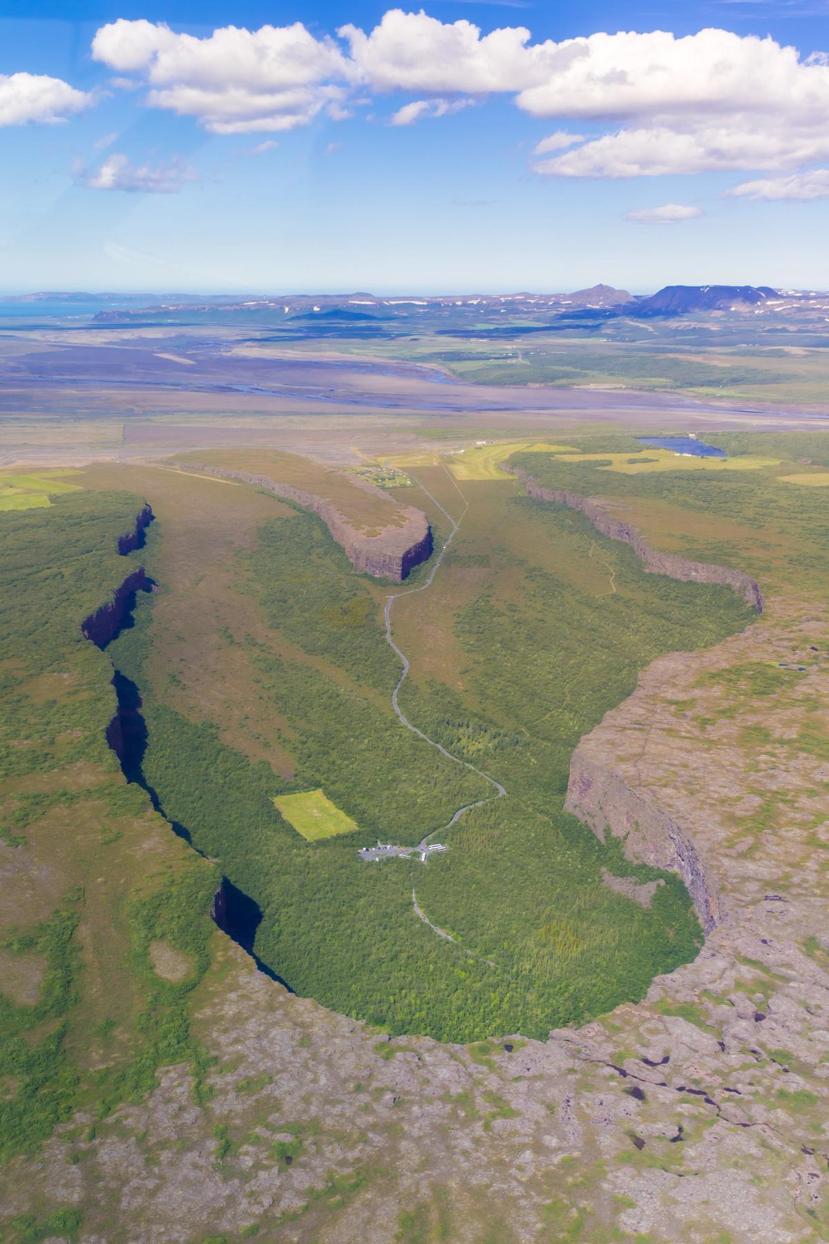 una vista aérea de un valle rodeado por montañas y árboles