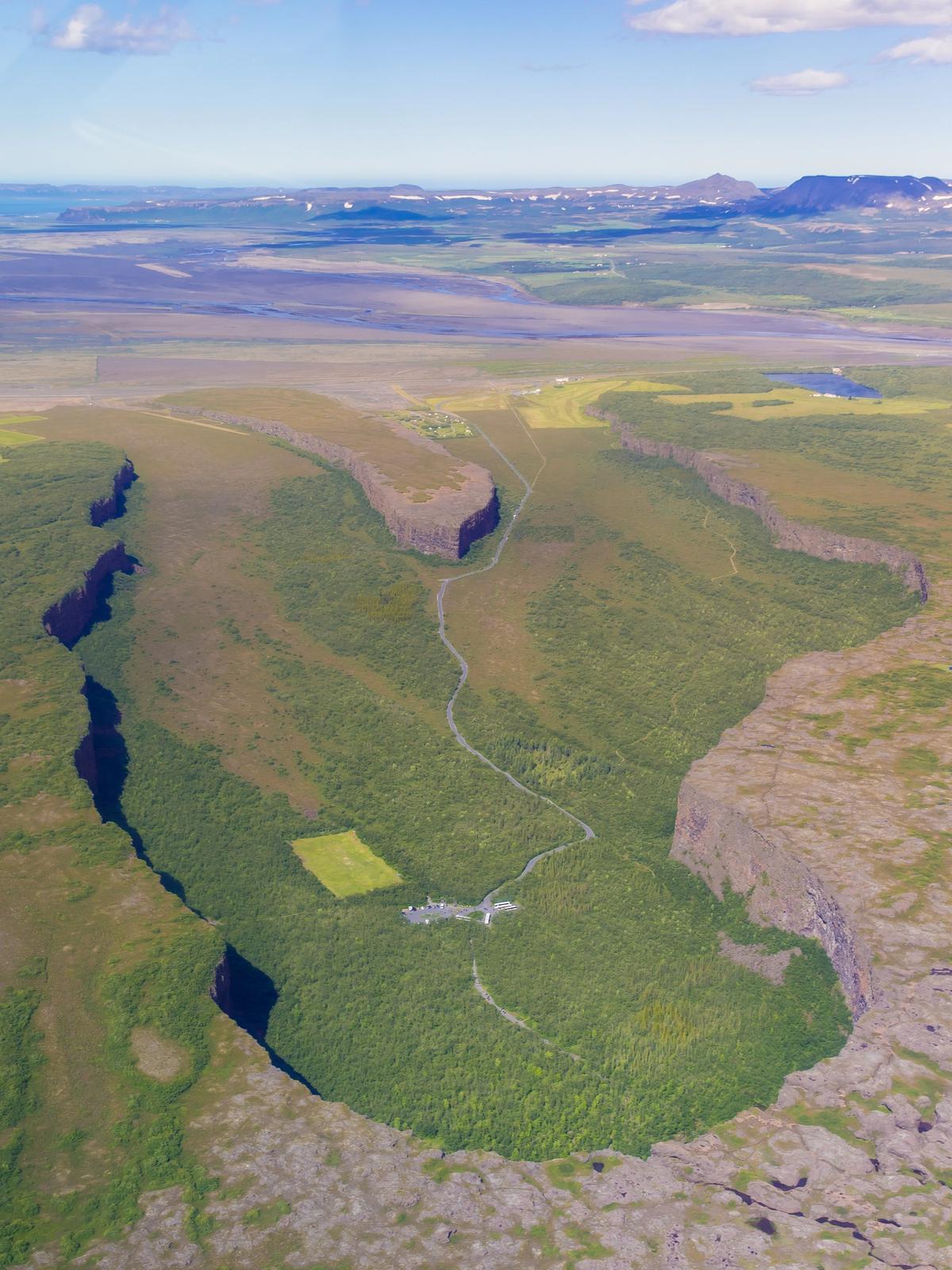 una vista aérea de un valle rodeado por montañas y árboles