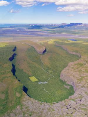 an aerial view of a valley surrounded by mountains and trees