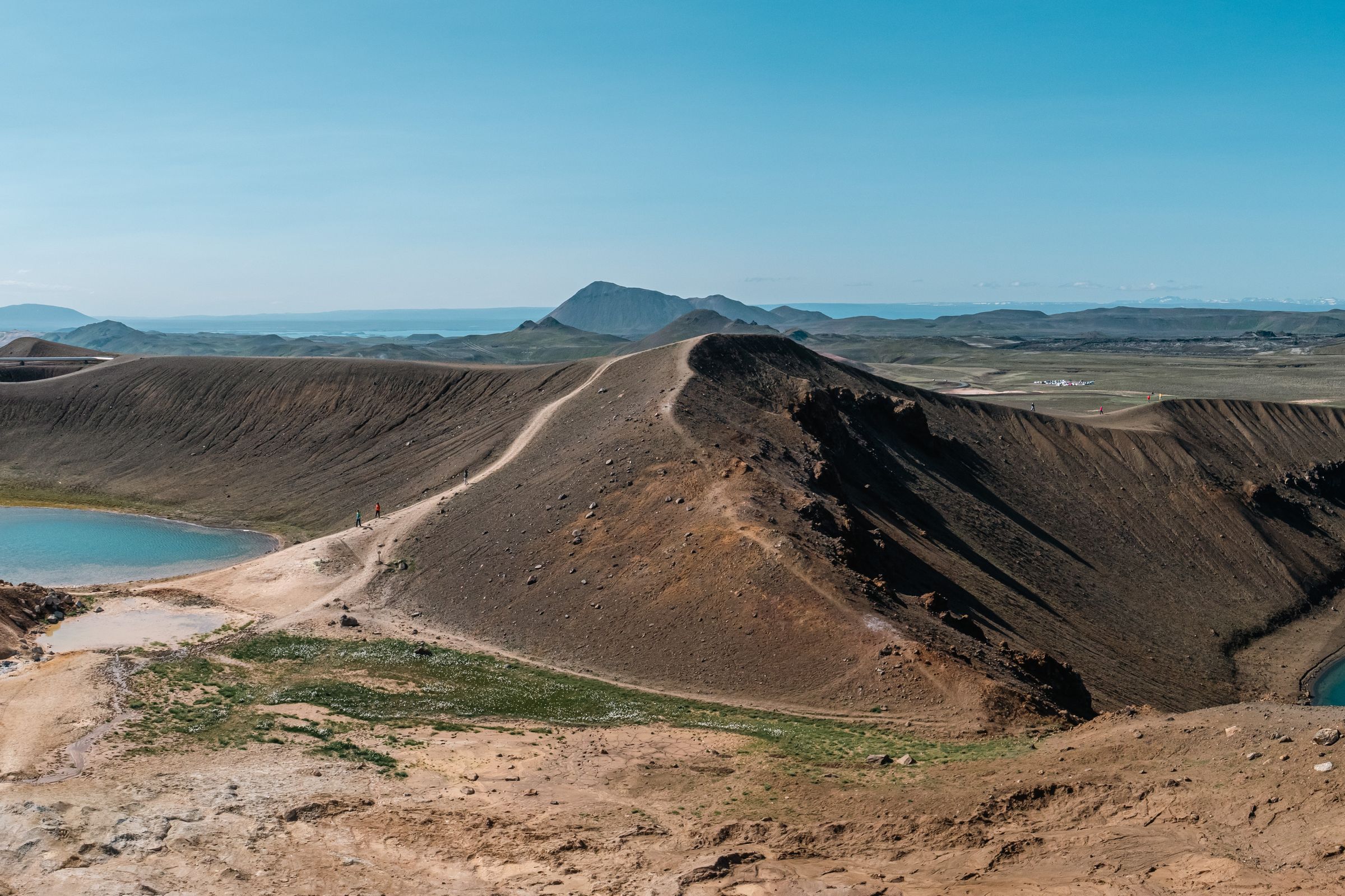 a panoramic view of a desert landscape with mountains and lakes at askja crater in east iceland.