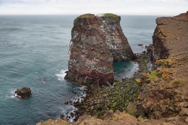 there is a large rock formation in the middle of the ocean .