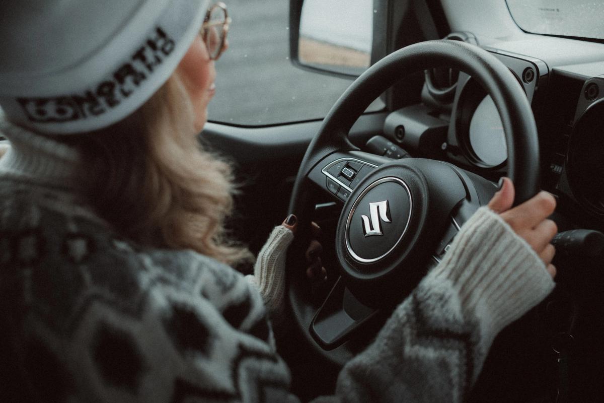 Mujer con gorro y gafas al volante de un Suzuki
