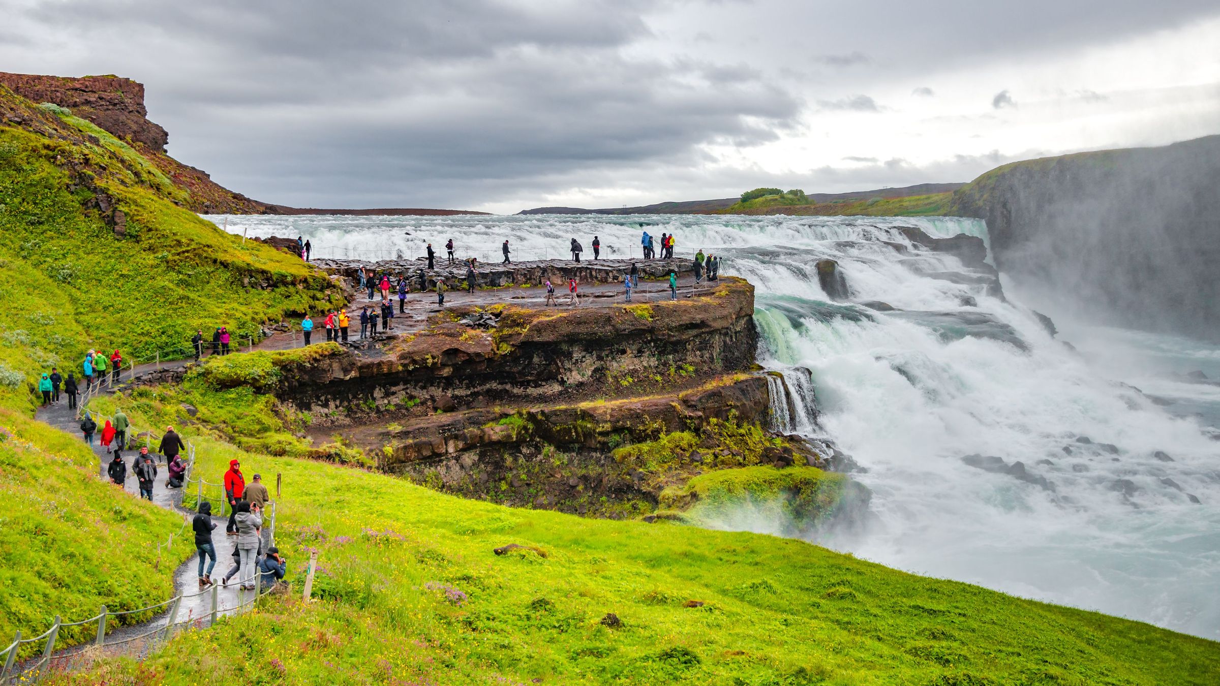 Un montón de gente viendo Gullfoss desde la parte izquierda de la cascada