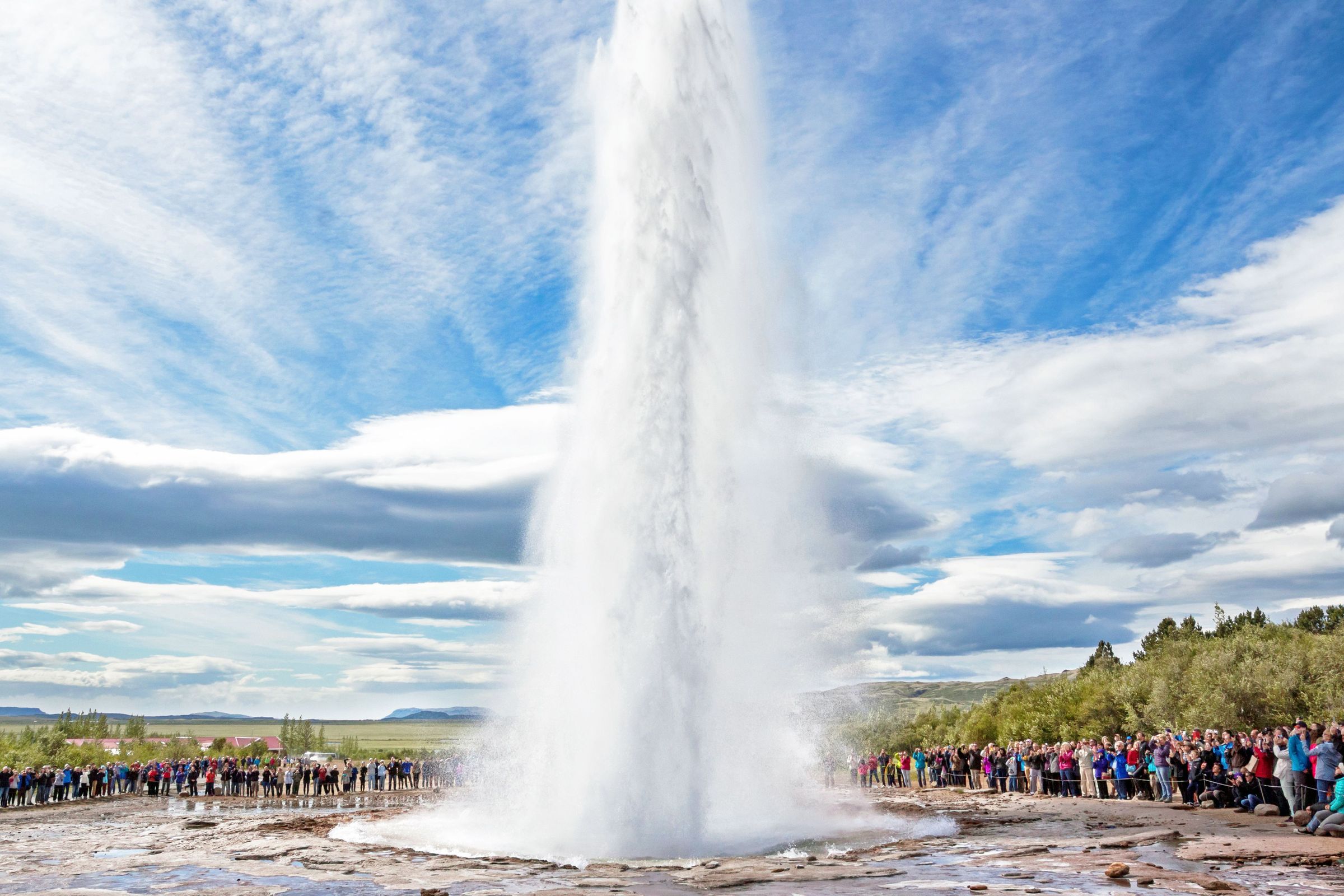 Groupe de personnes observant l'éruption d'un geyser