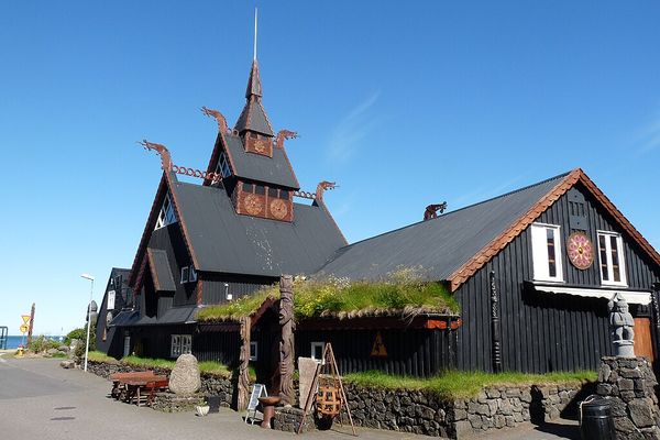 a large black building with a clock on its side.