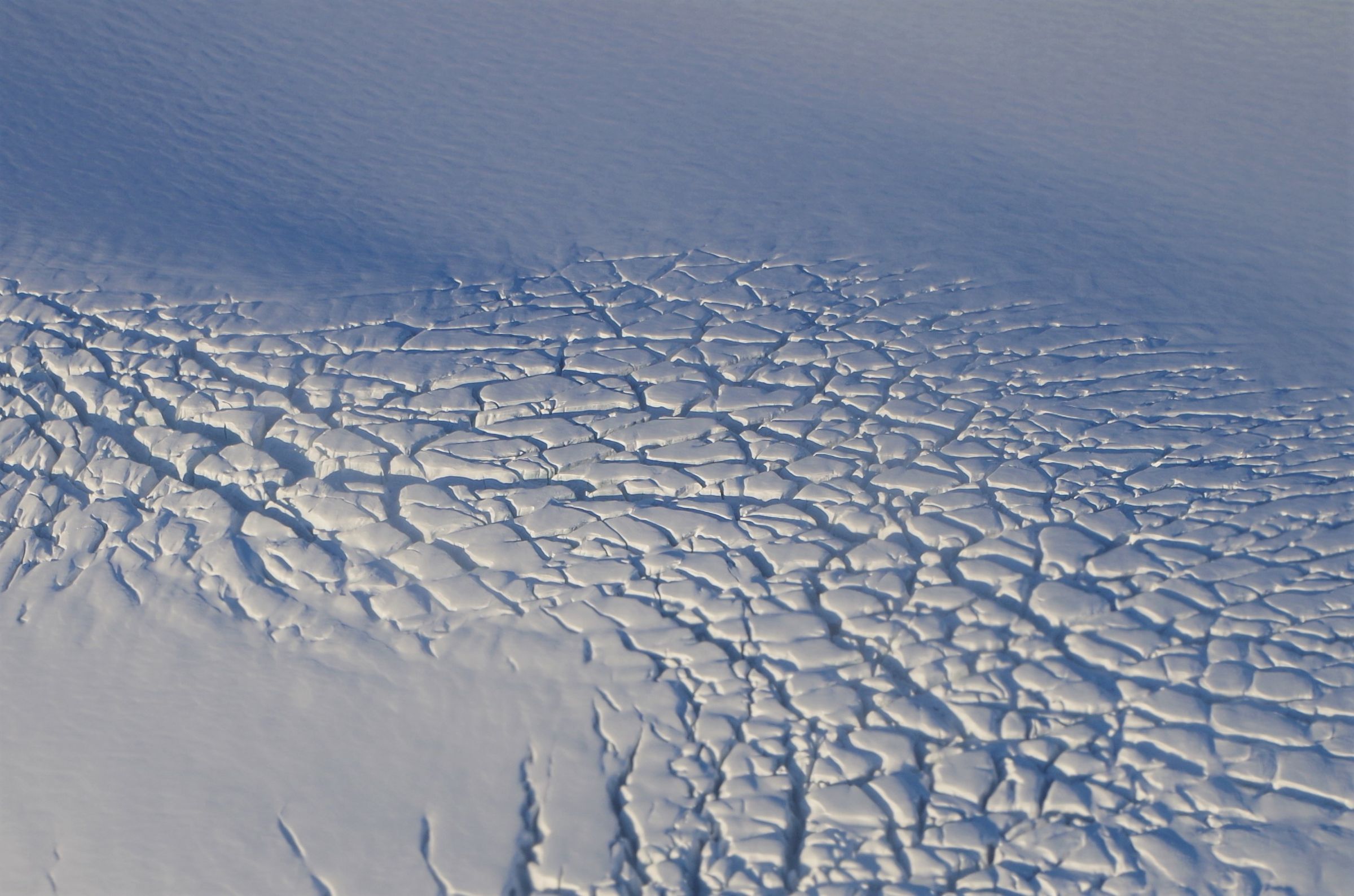 un gros plan d'une surface de neige fissurée