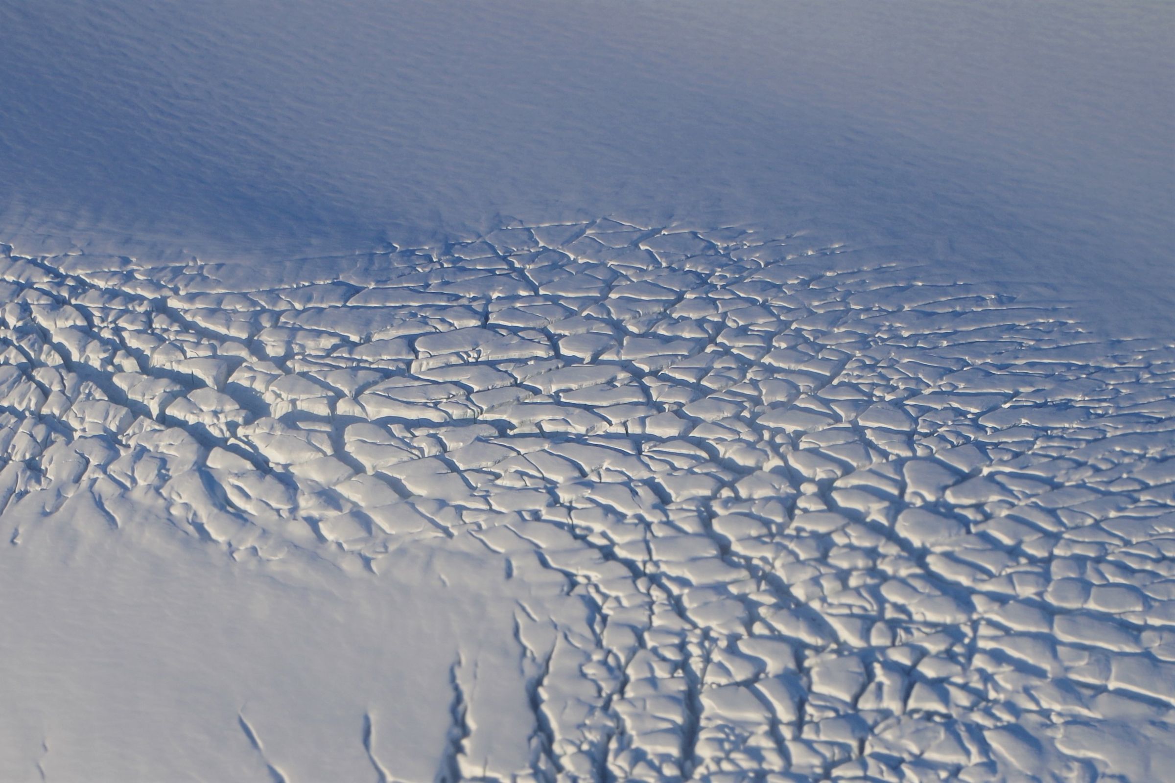 un gros plan d'une surface de neige fissurée