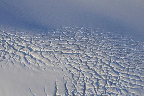 un gros plan d'une surface de neige fissurée