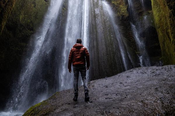 man standing in front of a waterfall