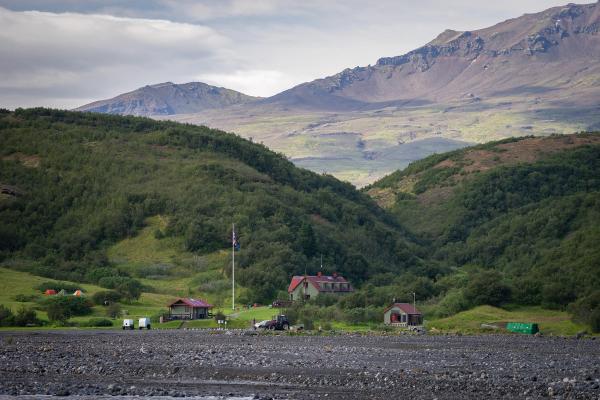 des cabanes en bois vertes au pied des collines verdoyantes