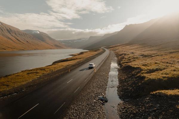 Rental car in the landscapes of Iceland Rental car on the road in Iceland, with a view of the mountains and water