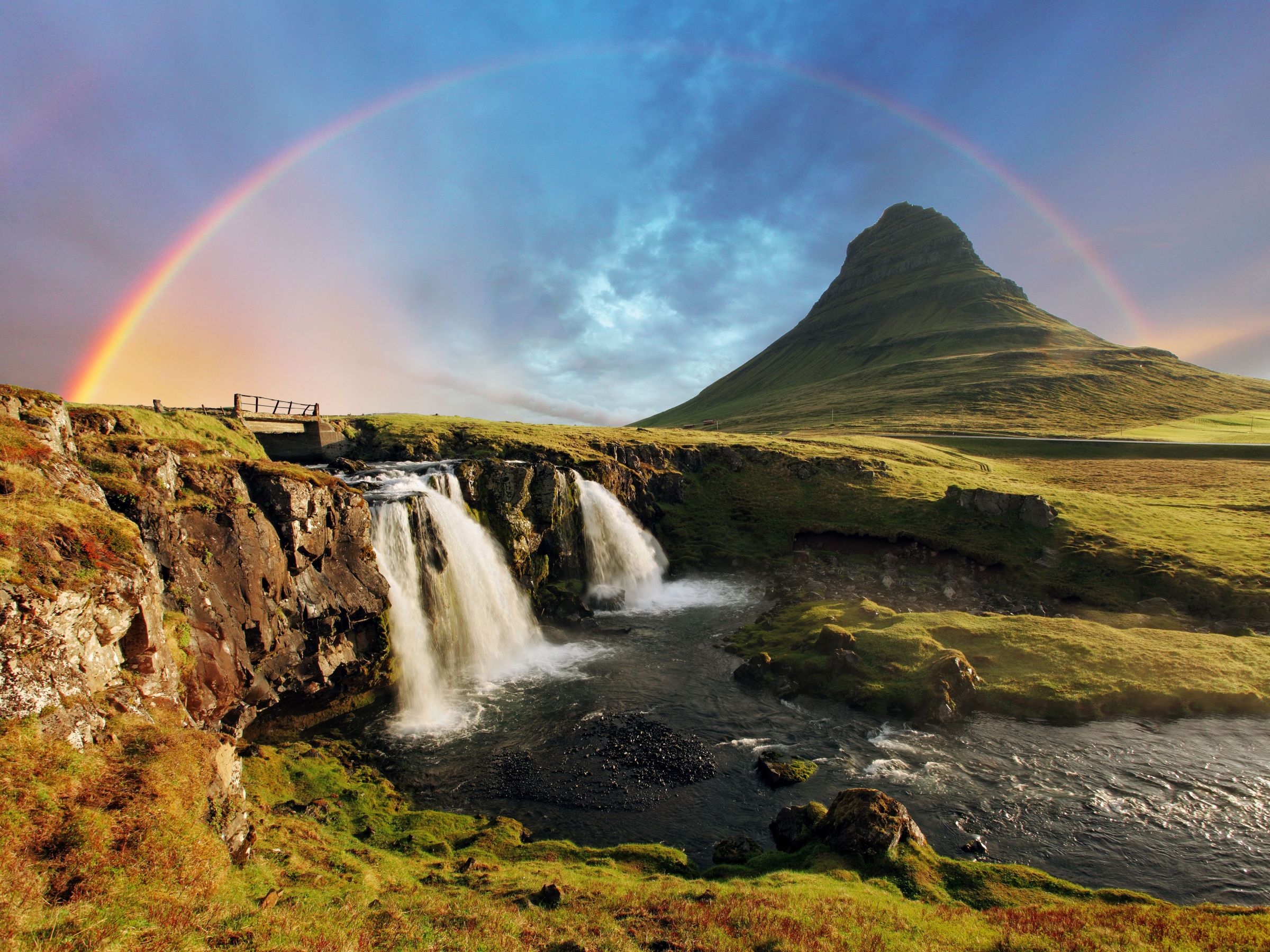 Kirkjufellsfoss and Kirkjufells with a rainbow