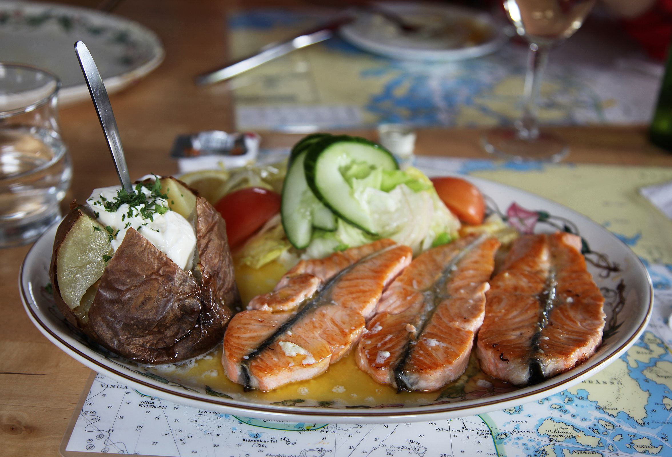 un plato de pescado con patata asada y verduras