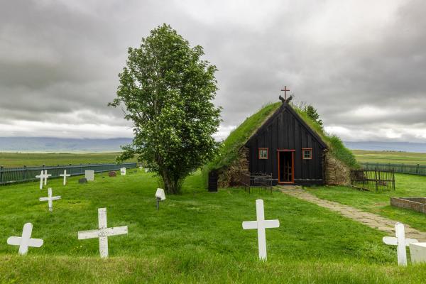 a black church with a green roof and white crosses in front of it .