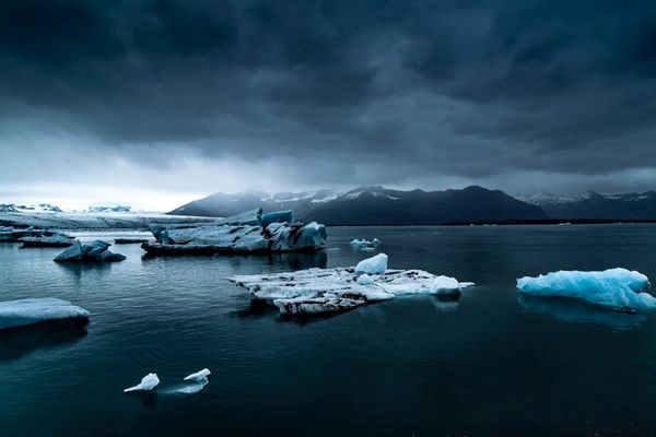 a group of icebergs floating on top of a body of water in iceland.