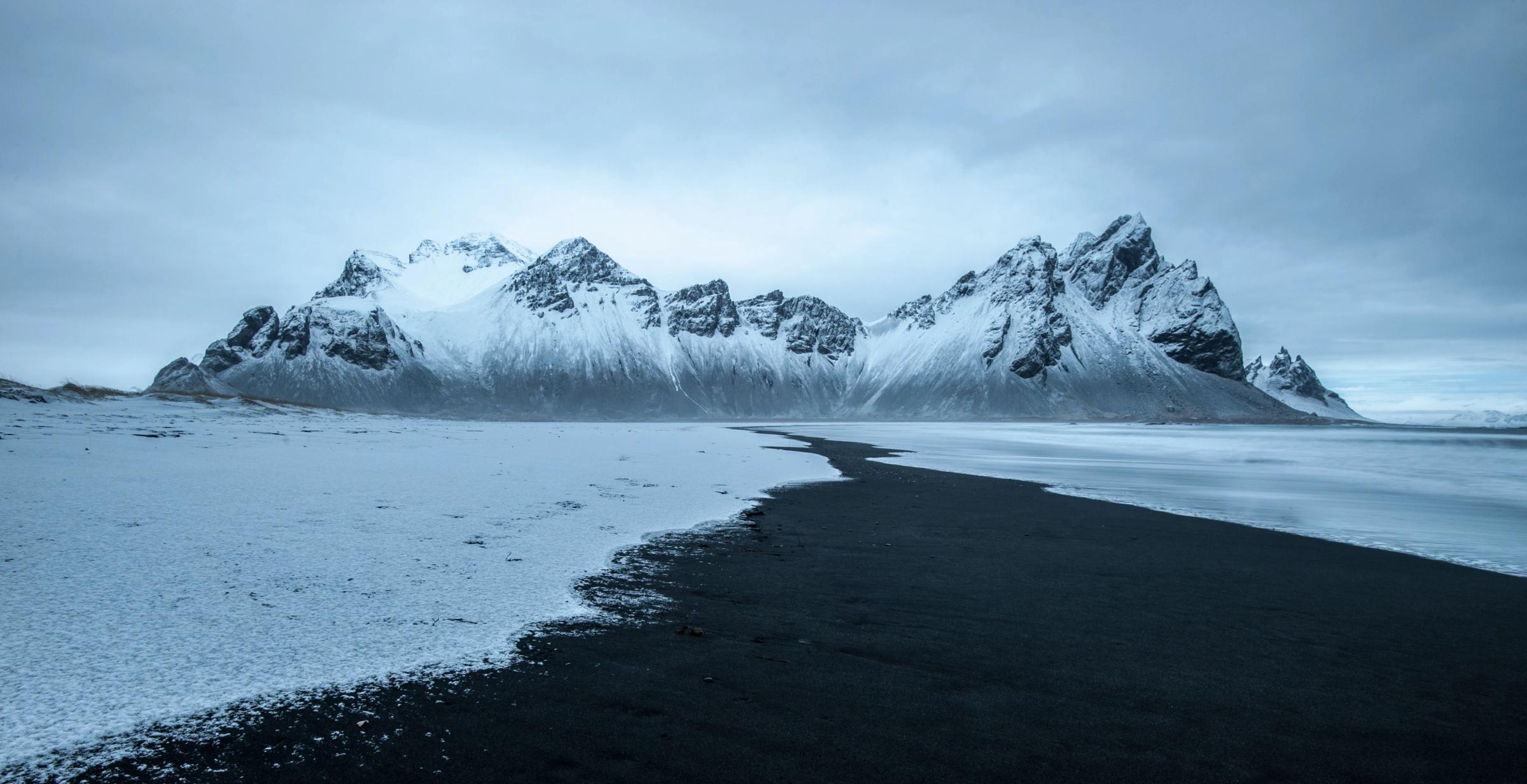 hermoso paisaje de la playa de Stokksnes, montañas nevadas y cielos nublados