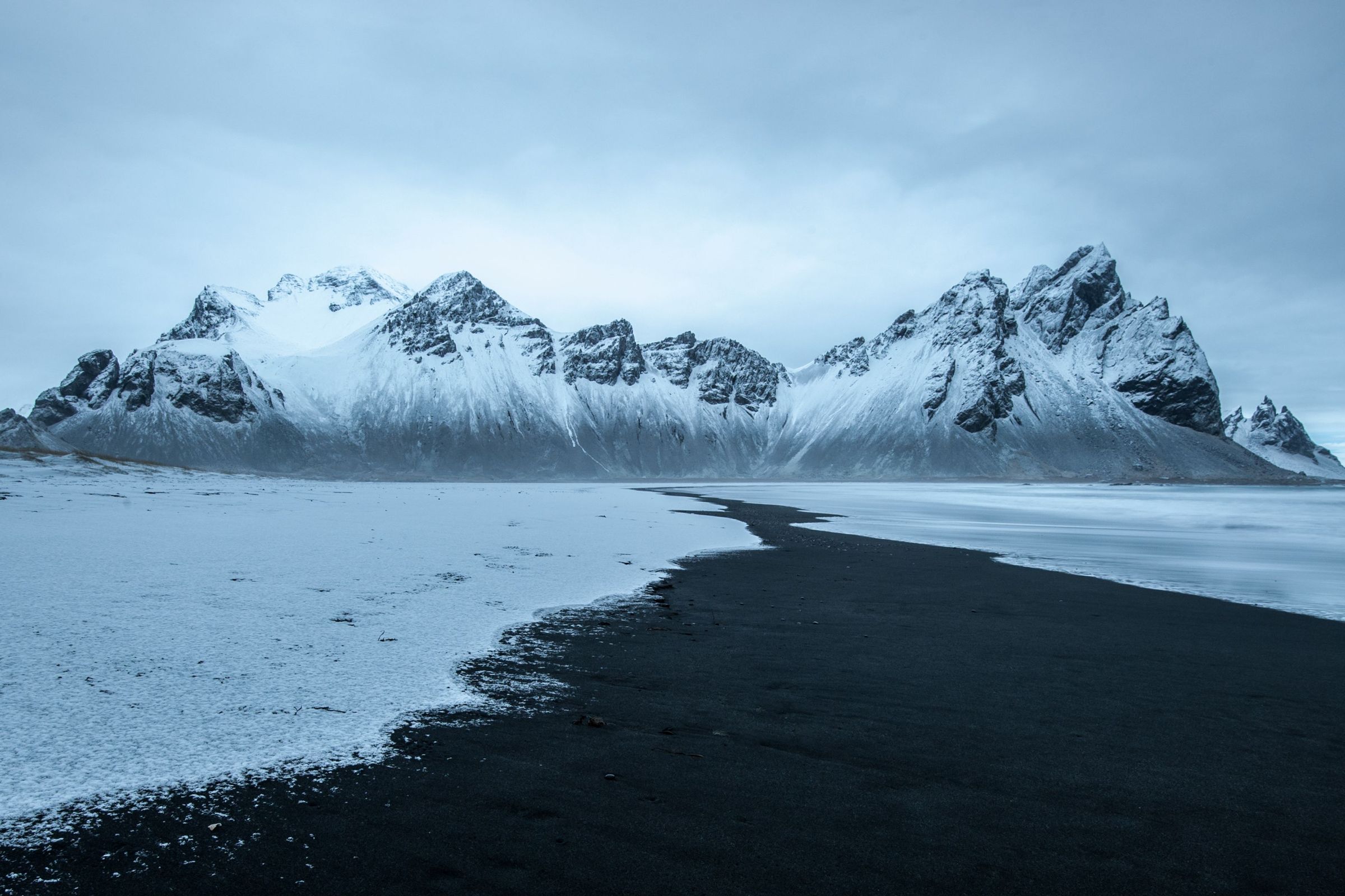 hermoso paisaje de la playa de Stokksnes, montañas nevadas y cielos nublados