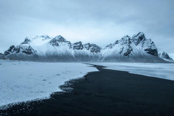 Stokksnes Black Sand Beach during winter beautiful landscape of Stokksnes beach, snow-capped mountains and overcast skies
