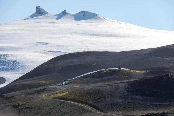 a group of cars are parked on top of a snow covered mountain .