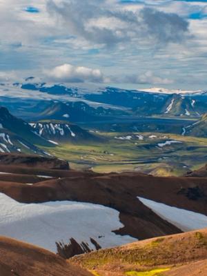 a group of people are standing on top of a snow covered mountain .