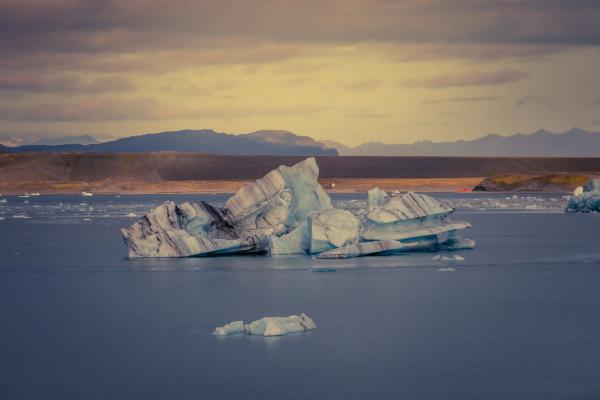 un gran iceberg está flotando sobre un cuerpo de agua .