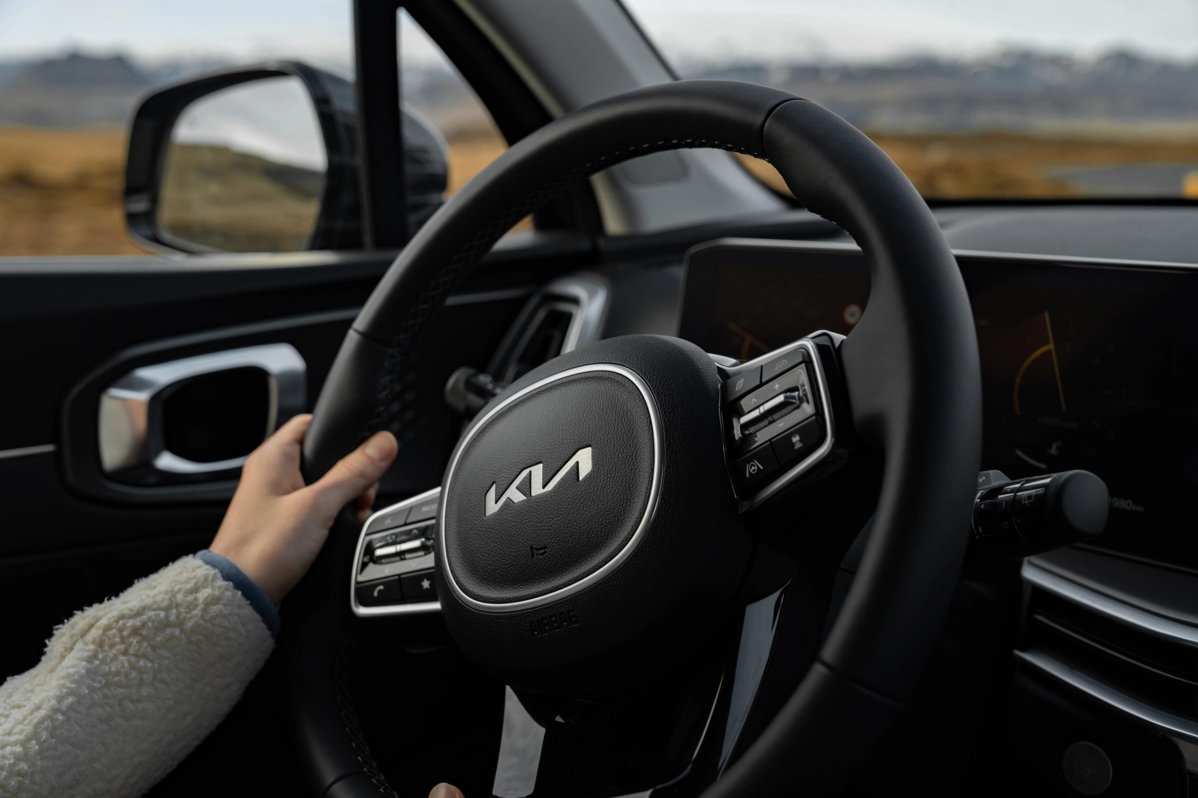 Gros plan sur le volant d’un Kia Sorento, avec une main posée dessus