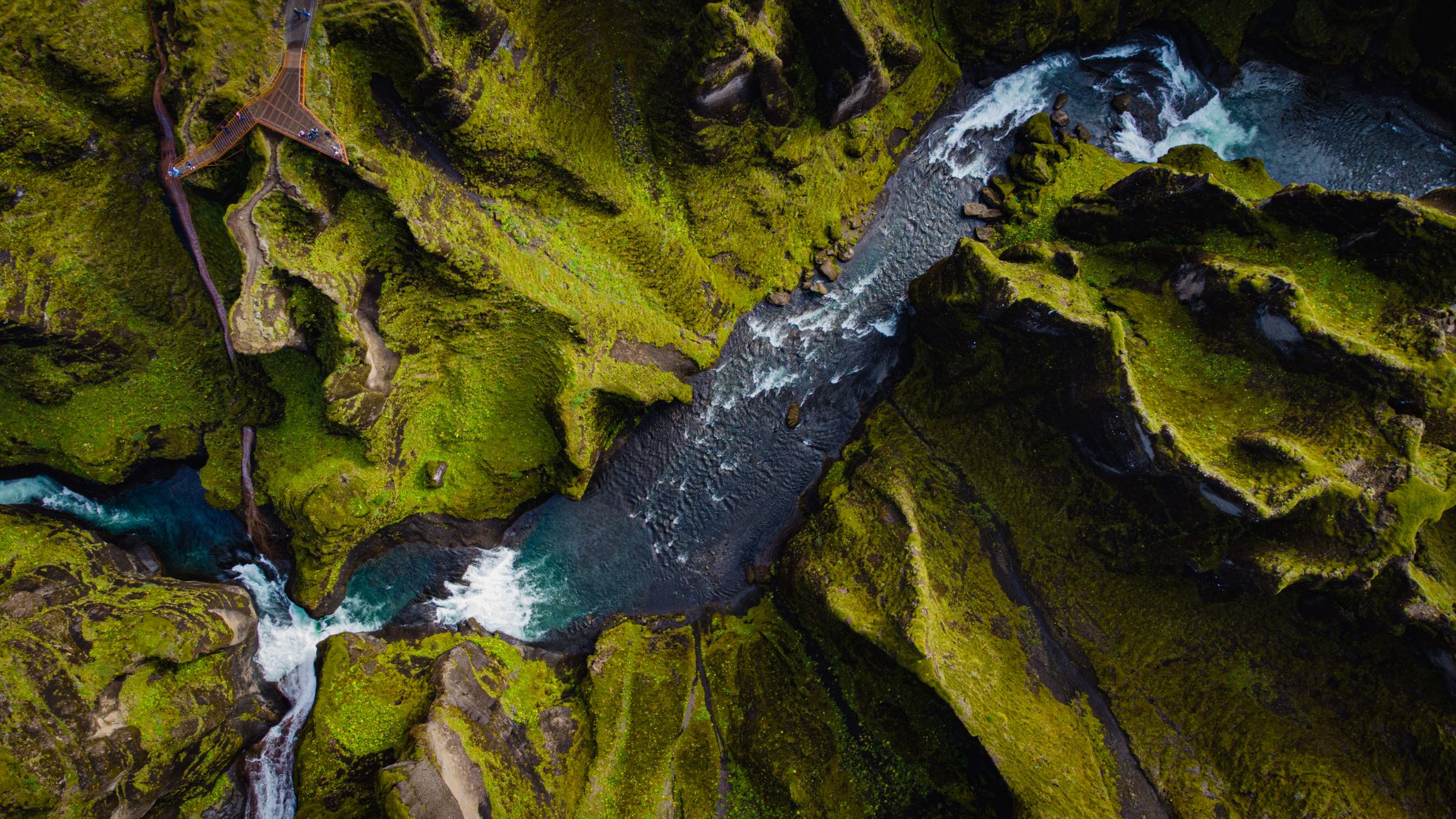 vue aérienne d'un canyon avec des parois couvertes de mousse et une rivière