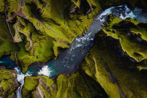 aerial view of a canyon with moss covered walls and a river