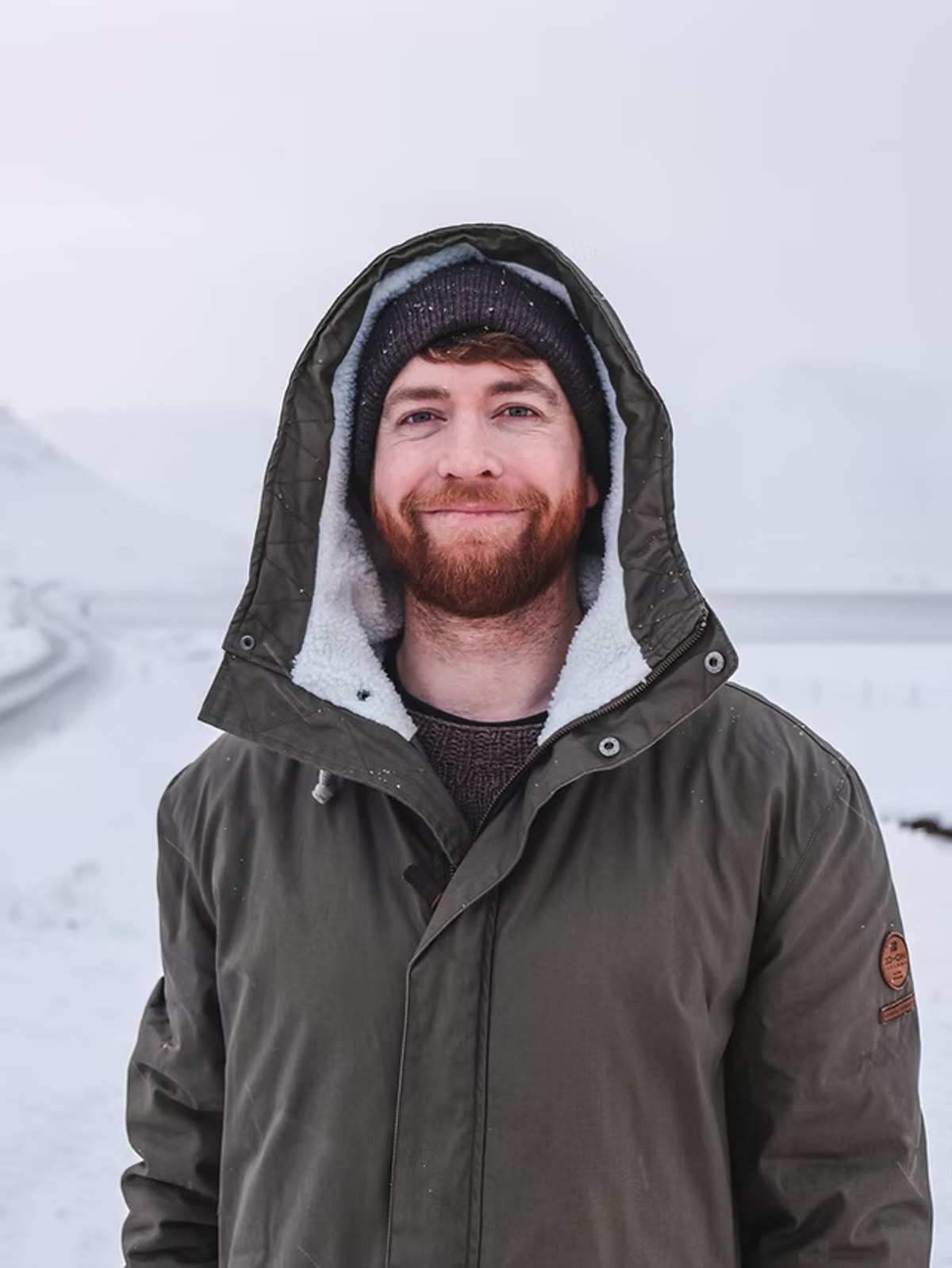 a man with a beard wearing a hooded jacket