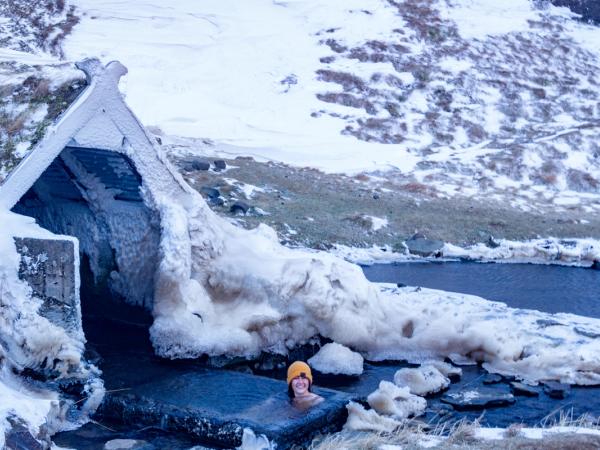 una persona se está bañando en un río congelado.