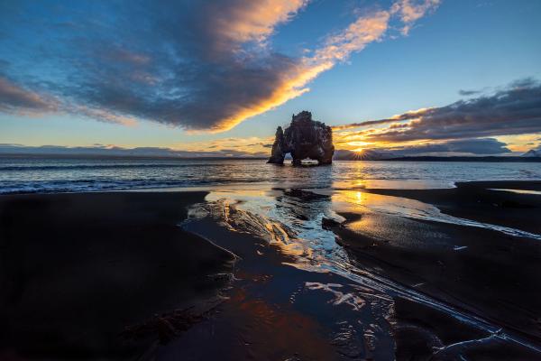 Dragon-shaped rock on the middle of the sea during sunrise