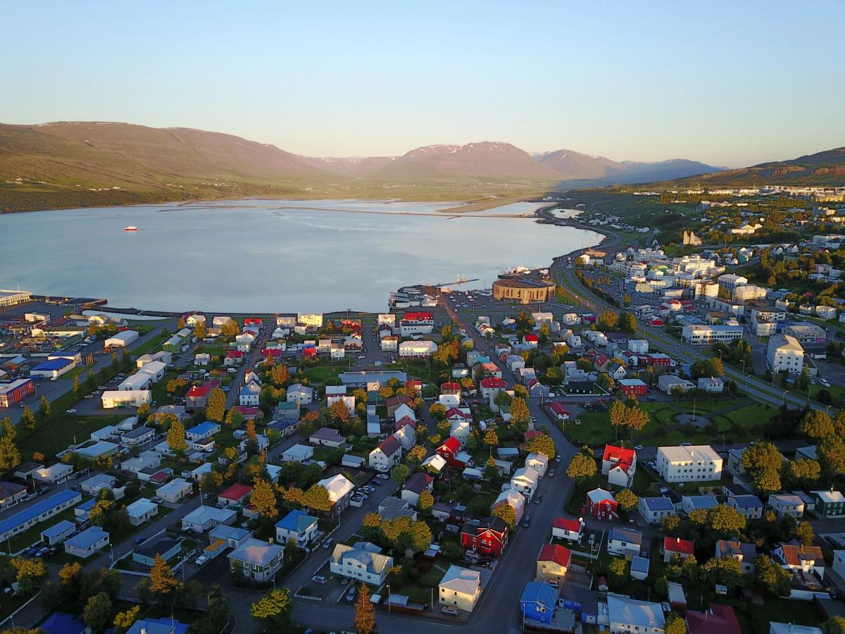 an aerial view of a city with a lake in the background and mountains in the background .