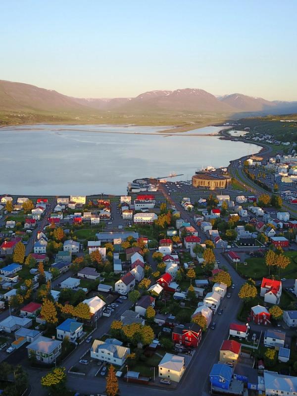 an aerial view of a city with a lake in the background and mountains in the background .