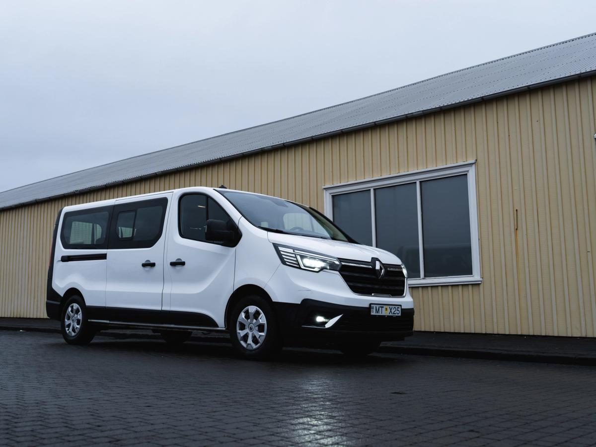 Vista lateral del tráfico Vista lateral de un monovolumen Renault Trafic aparcado junto a un edificio, alquiler de coches en Islandia