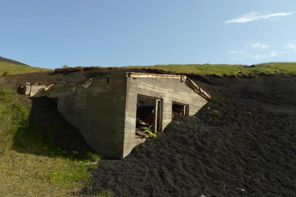 an old building is sitting on top of a pile of dirt .