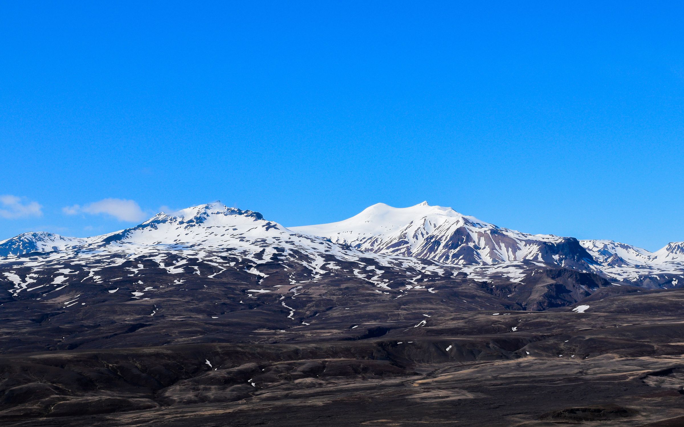 une chaîne de montagnes enneigées avec un ciel bleu en arrière-plan .