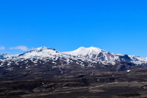 une chaîne de montagnes enneigées avec un ciel bleu en arrière-plan .