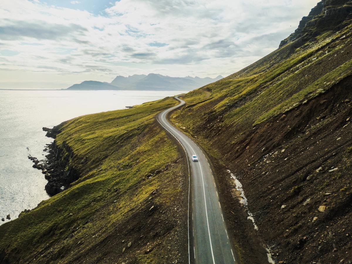 an aerial view of a car driving down a winding road .
