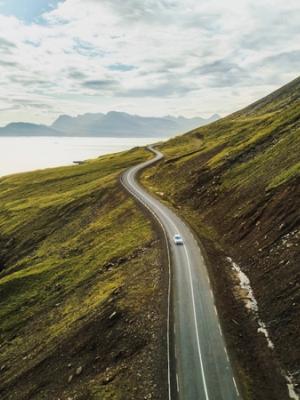an aerial view of a car driving down a winding road .