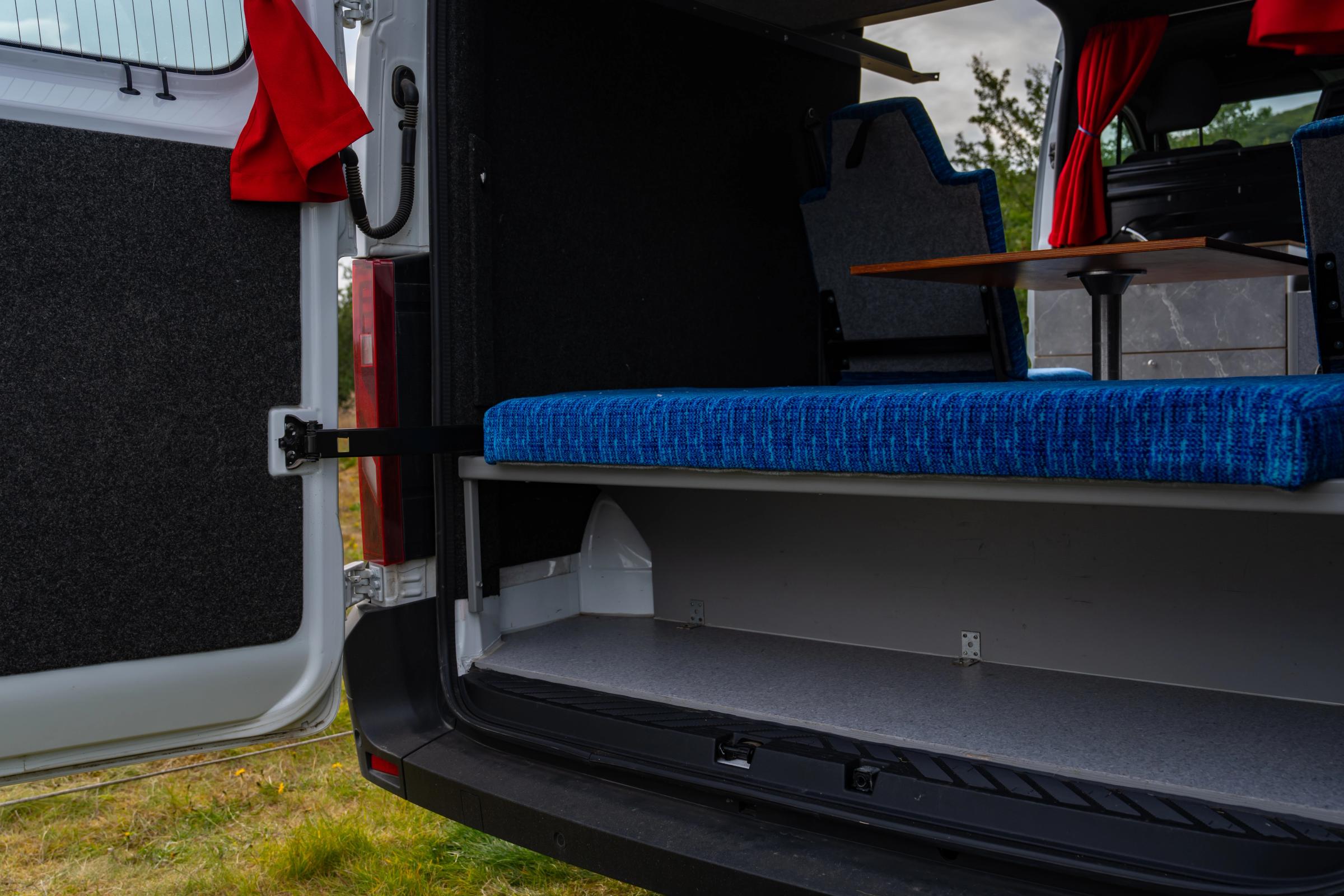 Storage space under the rear bench behind the back doors of a 5 person large camper