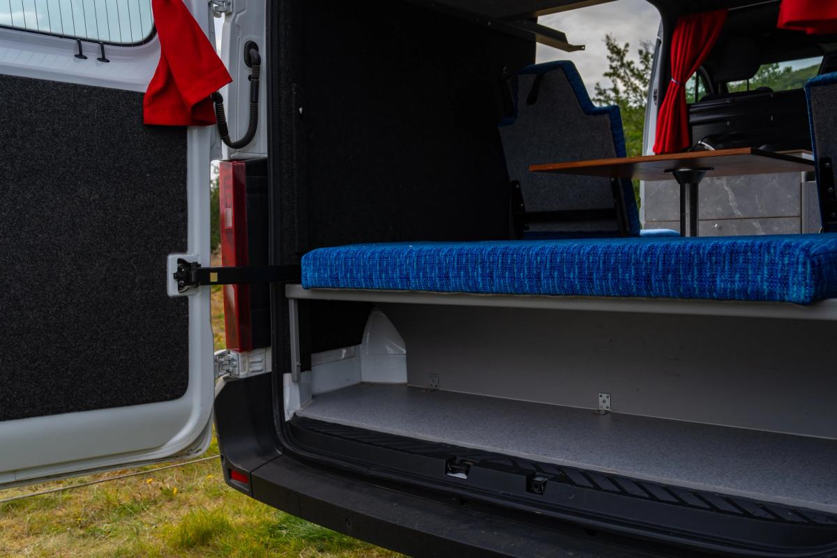 Storage space under the rear bench behind the back doors of a 5 person large camper