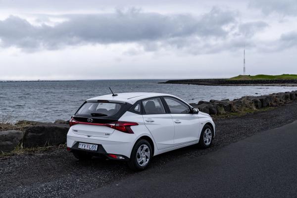 Enjoy the serene coastal vistas of Iceland with our white Hyundai i20 rental car. White Hyundai i20 rental car parked by the seaside in Iceland.