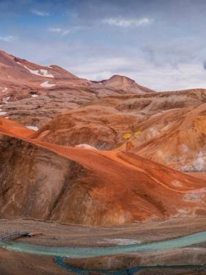 there is a river running through the mountains in the background at Kerlingarfjöll in iceland.