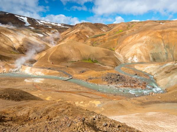 a river running through a valley surrounded by mountains .