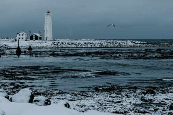 Peninsula fully covered in snow with a white lighthouse